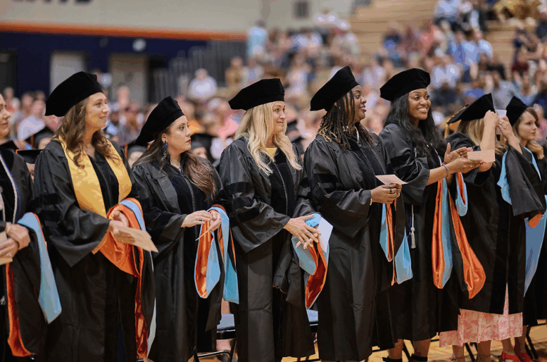grad students stand during commencement ceremonies